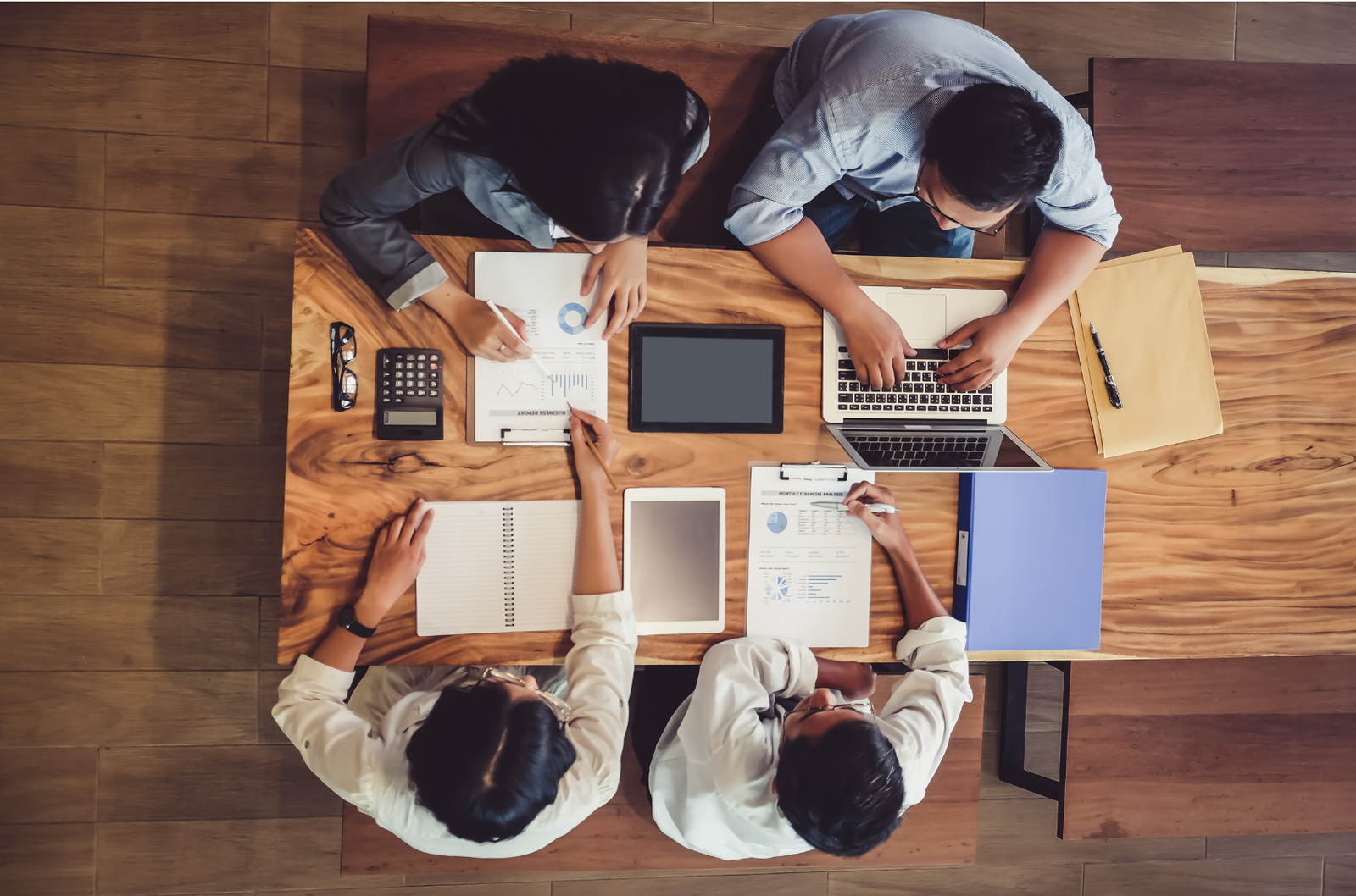 Overhead view of a team working together with laptops and documents
